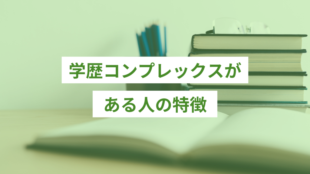 デスクの奥に積み上げられた本5冊と、左に青い鉛筆がたくさん入った鉛筆たて、その手前に開いた状態の白いノート