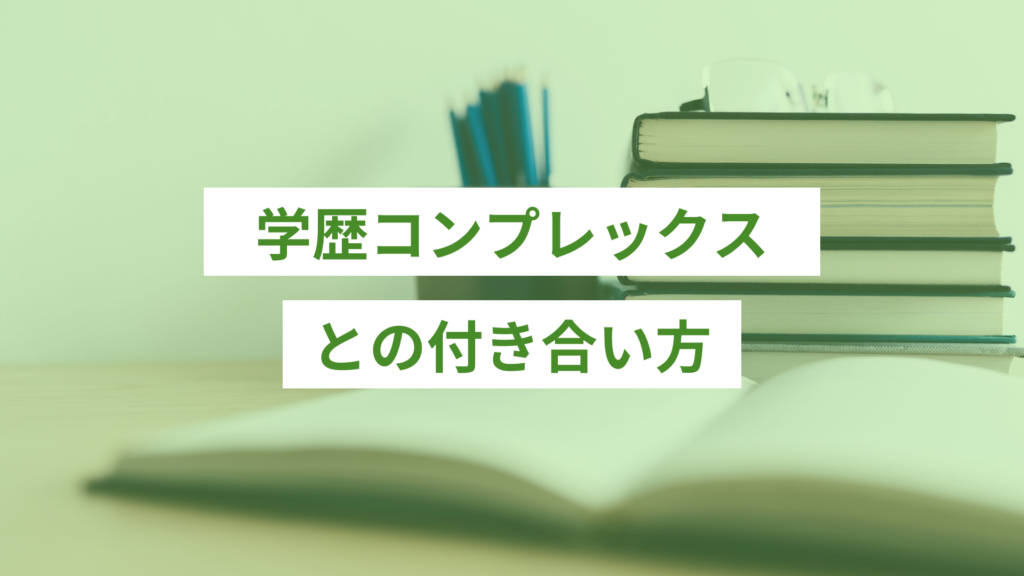 デスクの奥に積み上げられた本5冊と、左に青い鉛筆がたくさん入った鉛筆たて、その手前に開いた状態の白いノート