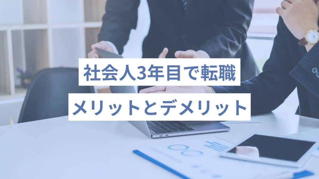 スーツの男性二人が、デスクに資料を広げながら１台のノートパソコンを一緒にみて指さしながら何かを話し合っている様子