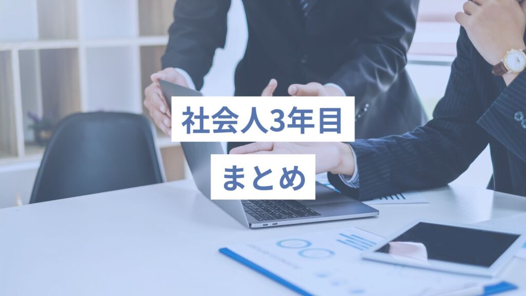 スーツの男性二人が、デスクに資料を広げながら１台のノートパソコンを一緒にみて指さしながら何かを話し合っている様子