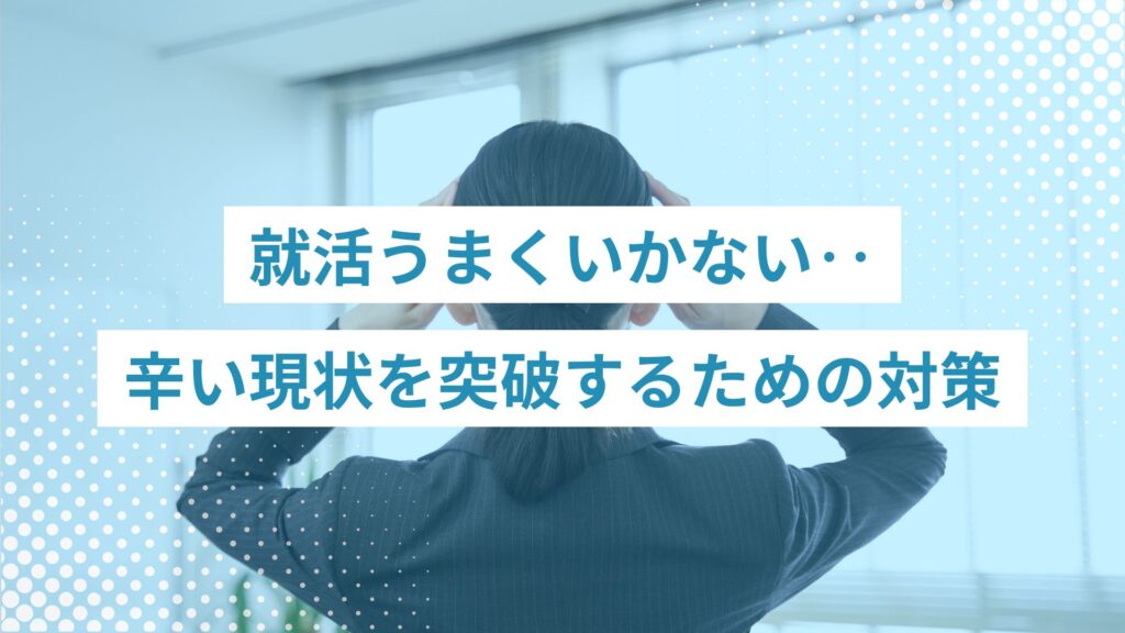 黒のミディアムヘアを後ろで１本にまとめているスーツ姿の若い女性が頭を抱えている後ろ姿