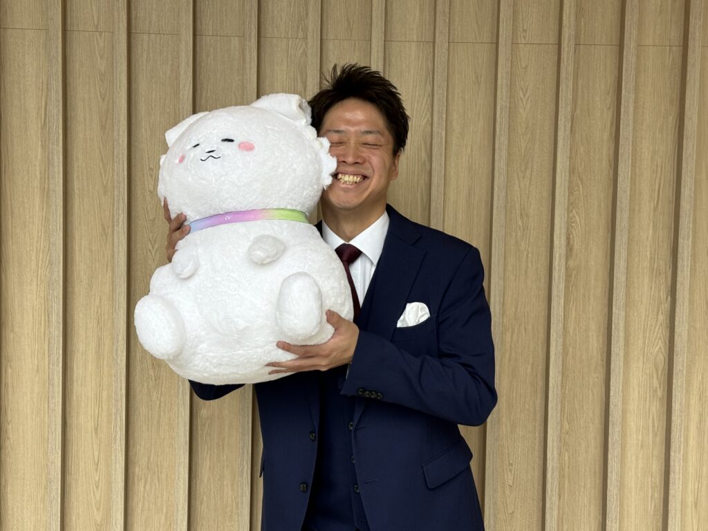 ONEマーケ創設者：満武和樹さんとワンマー犬（ぬいぐるみ）のツーショット