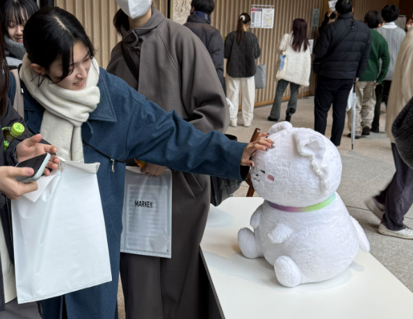 コンベンション来場者に撫でられるワンマー犬（ぬいぐるみ）